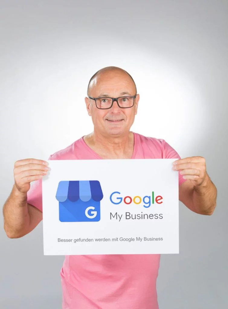 Peter Haurand, Profi für Google My Business bearbeiten, zeigt Schild mit Google My Business.