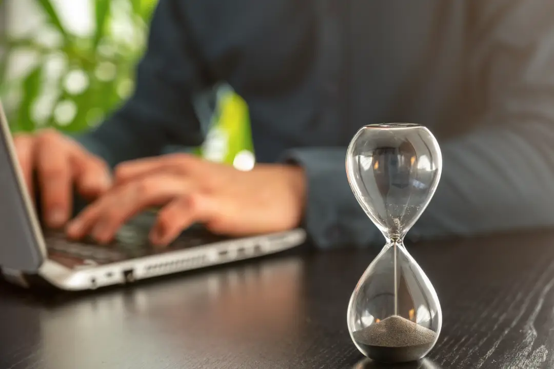 Laptop, Mann und Sanduhr symbolisieren den Countdown zum Barrierefreiheitsstärkungsgesetz