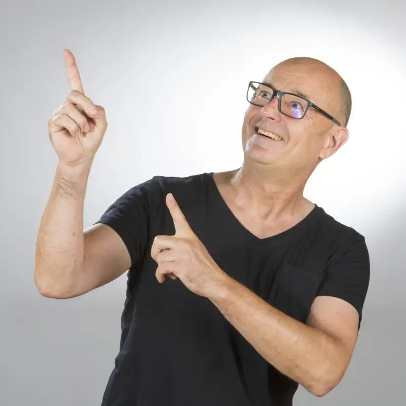 Webdesigner Peter Haurand zeigt mit beiden Armen nach links oben