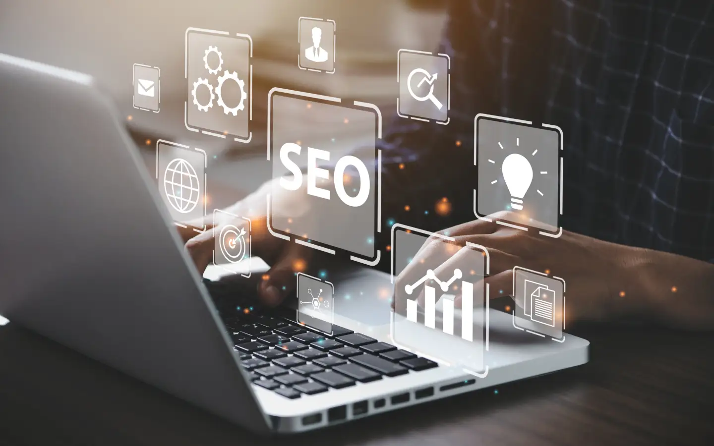 An einem Laptop arbeitet eine Person und es sind mehrere digitale Symbole rund ums Thema SEO-Strategie eingeblendet